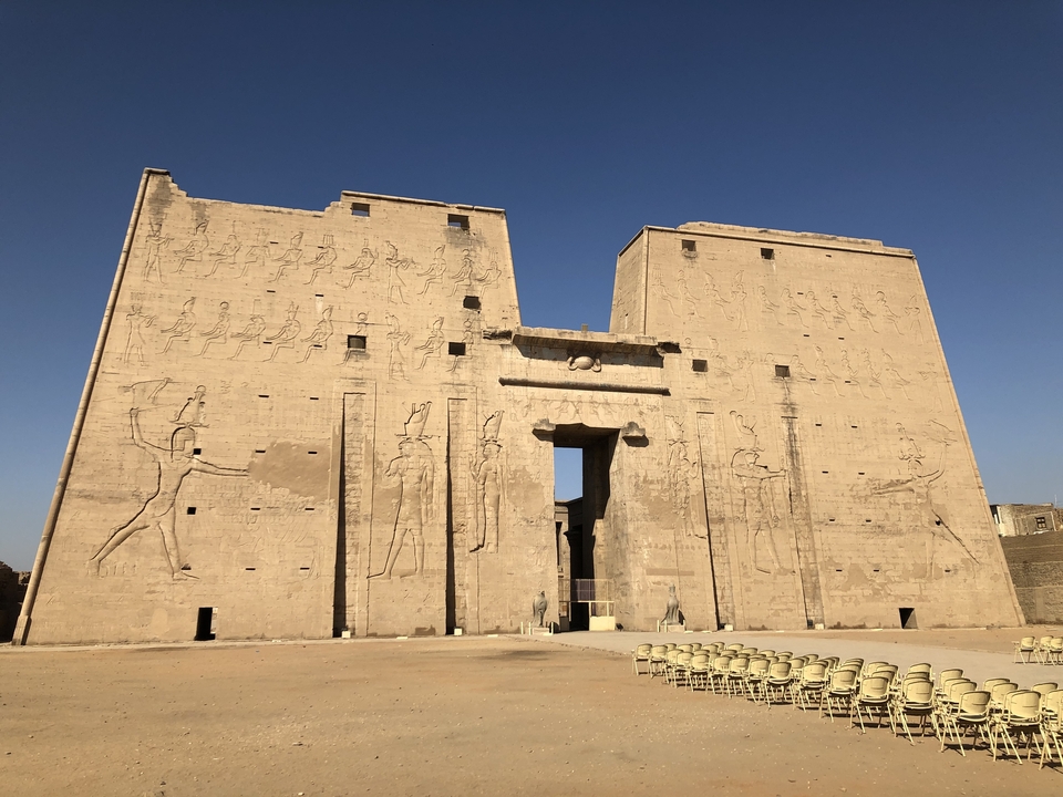 Entrée d'un grand temple ancien avec des sculptures.