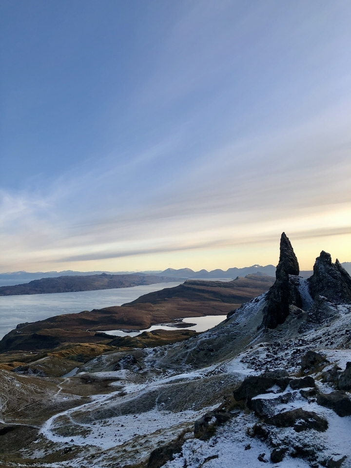 Mountainous coastal landscape with ocean views and distant peaks.