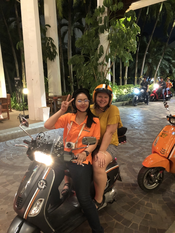 Deux femmes posant sur une moto dans un complexe hôtelier.