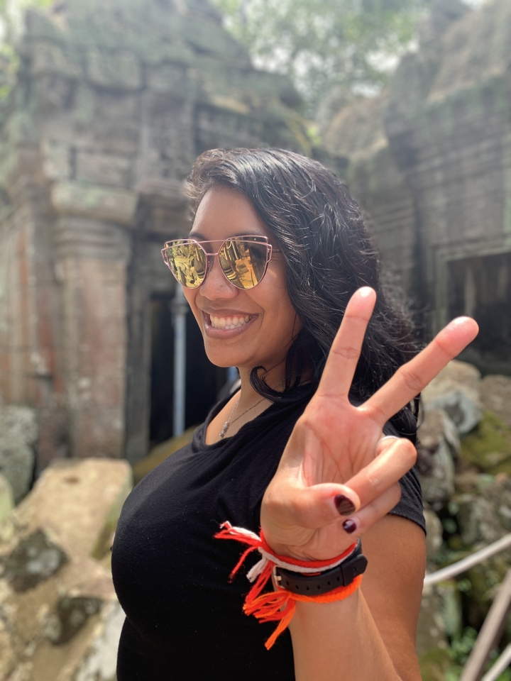 Portrait en gros plan d'une personne souriante faisant le signe de la paix.