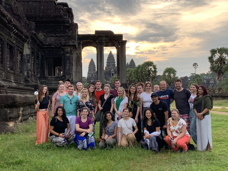 Un grand groupe de touristes debout devant Angkor Vat.