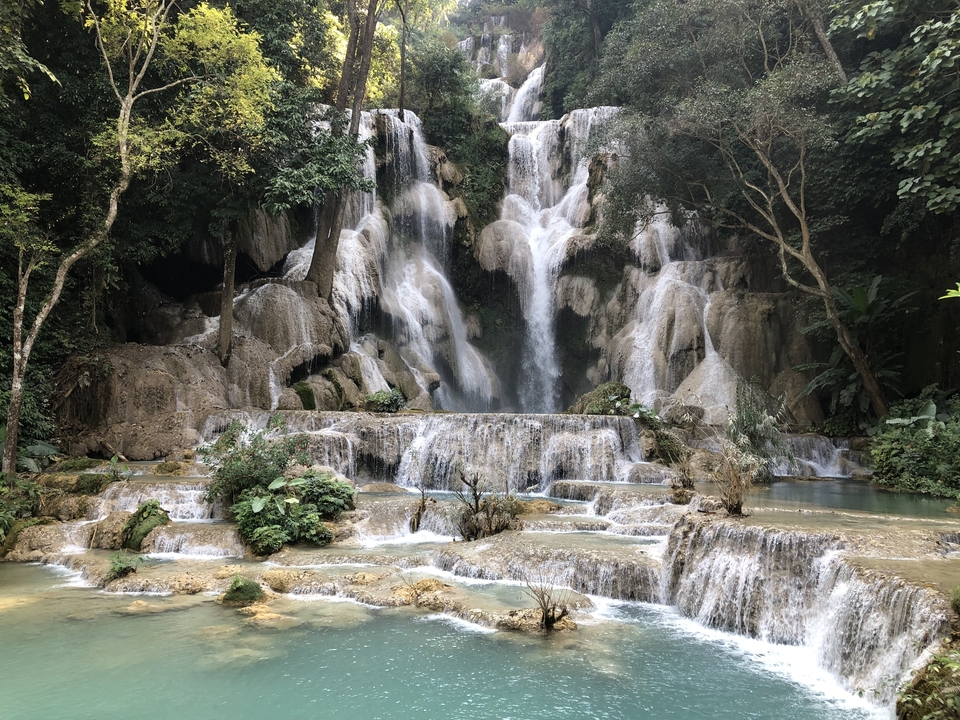 Groupe posant devant des chutes d'eau en cascade.