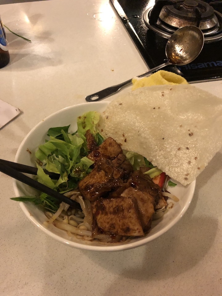 Bol de nourriture avec des légumes et de la viande grillée et un grand cracker.