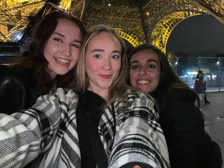 Trois personnes posant devant une structure éclairée.