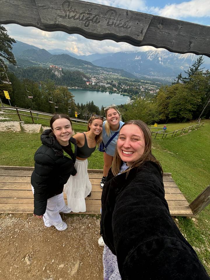 Photo de groupe avec vue sur un lac et une petite ville au loin.