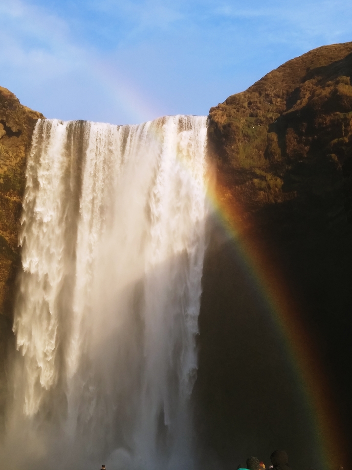 Cascade avec un arc-en-ciel dans la brume.