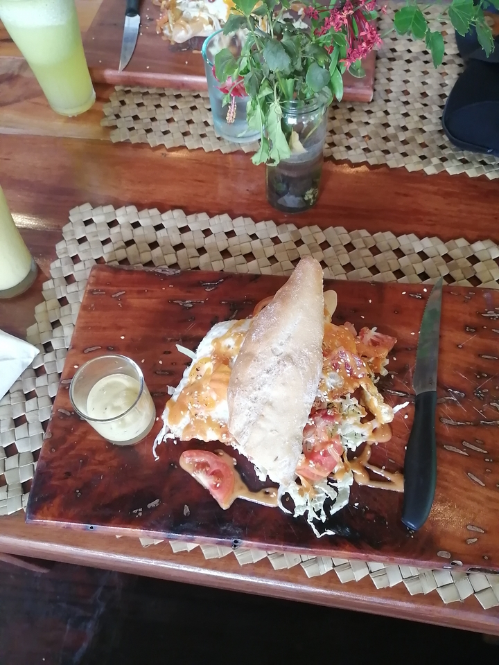Assiette de nourriture avec un pain de style focaccia et de la sauce sur un plateau en bois.