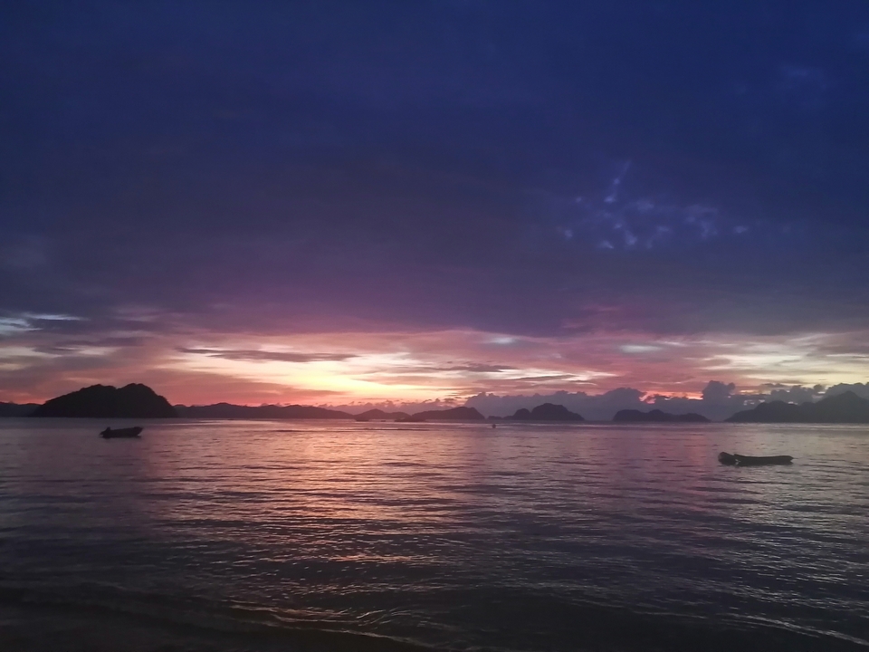 Coucher de soleil sur l'océan avec de petites îles et un ciel dramatique.