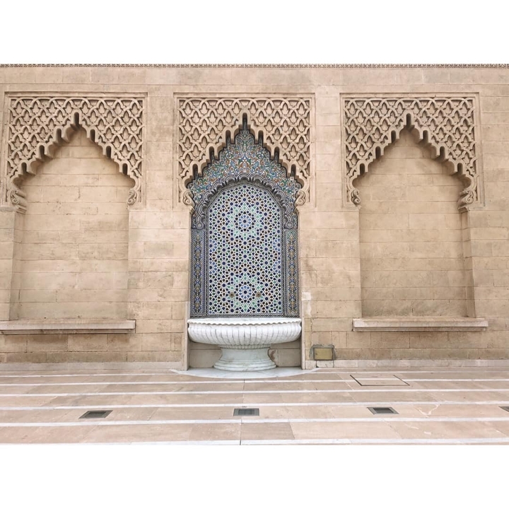 Decorative stone wall with ornate tile art.