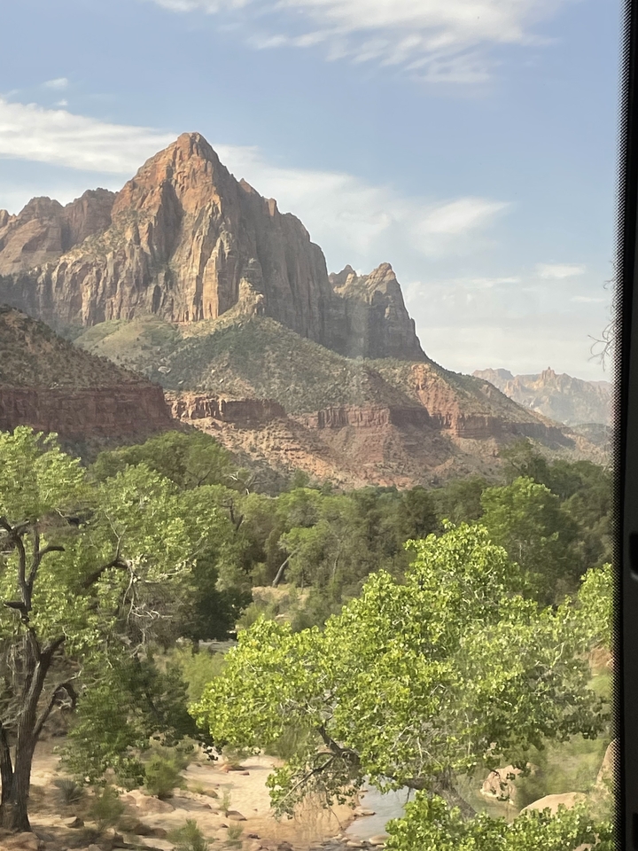 Vue depuis la fenêtre d'un véhicule d'un paysage accidenté et de verdure.