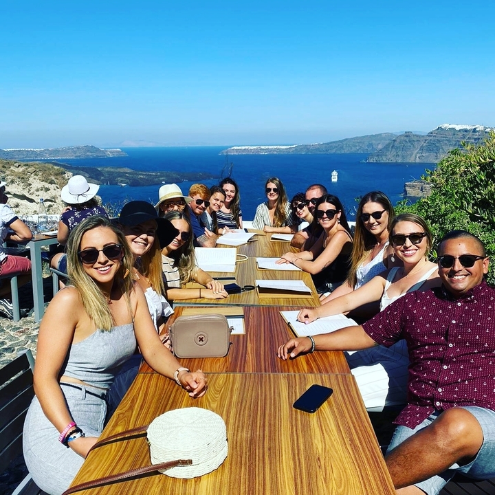 Group dining with a view of the Santorini caldera.