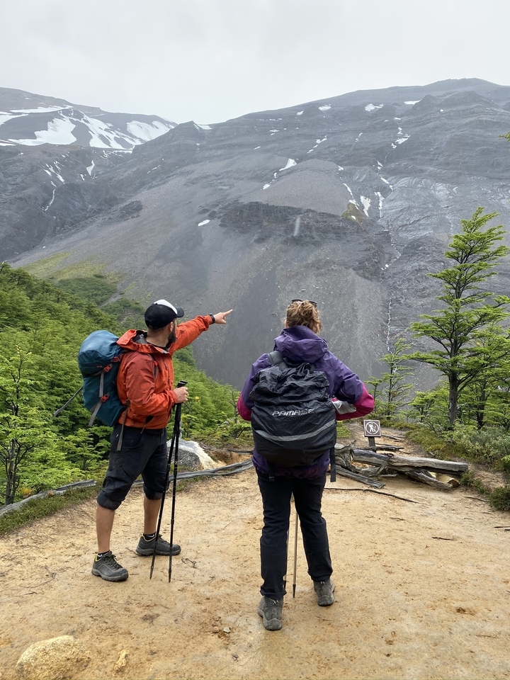 Deux randonneurs pointant du doigt une montagne lointaine.