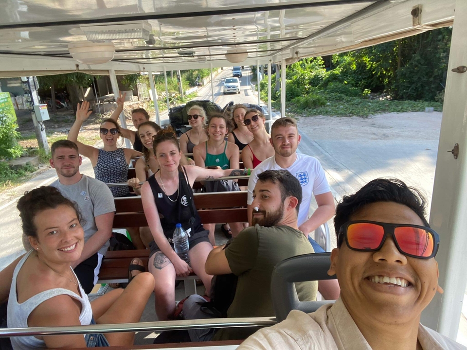 Group of people on an open tram ride.
