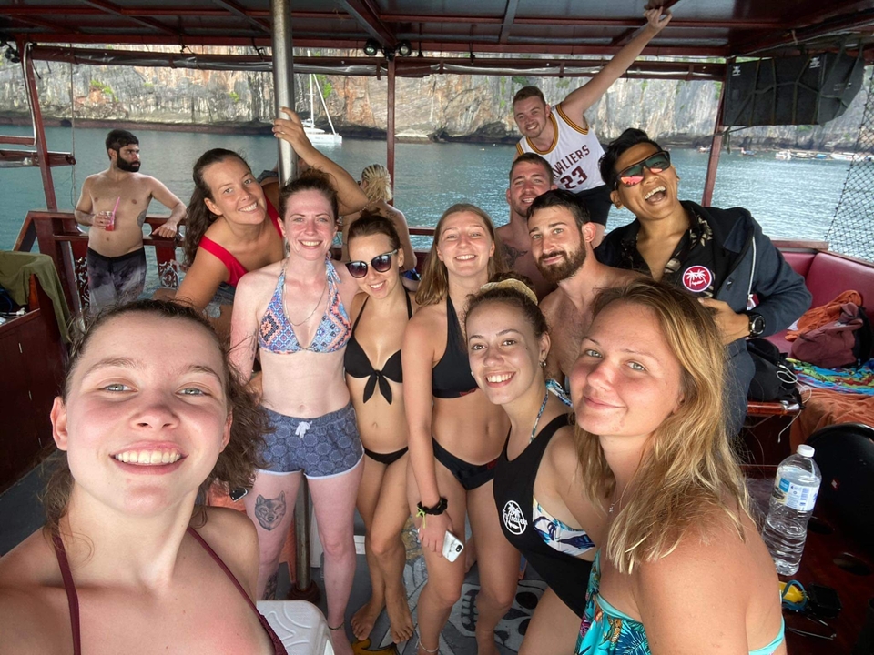 Group photo of people in swimwear on a boat.