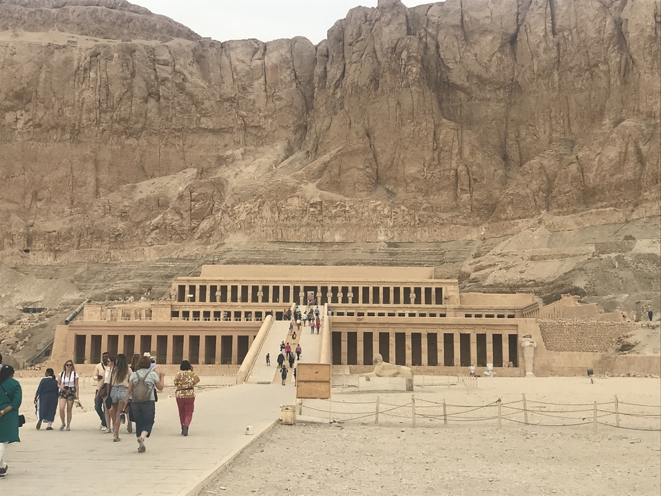 Des touristes près de l'entrée d'un grand temple.