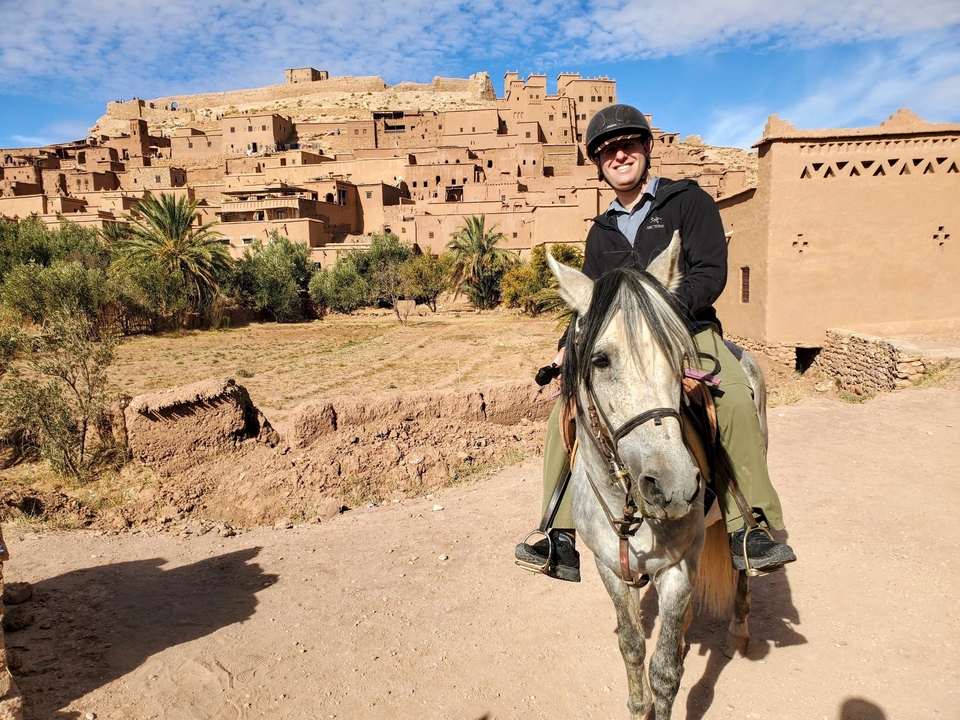 Personne à cheval avec des bâtiments historiques en arrière-plan.