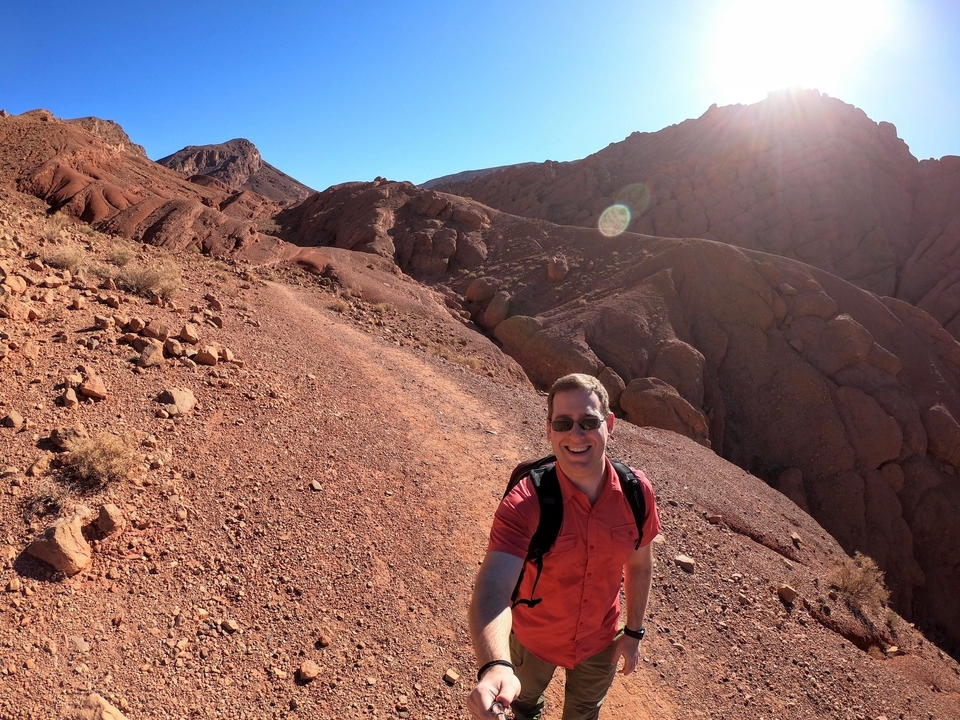 Personne faisant de la randonnée dans un paysage désertique rocheux.