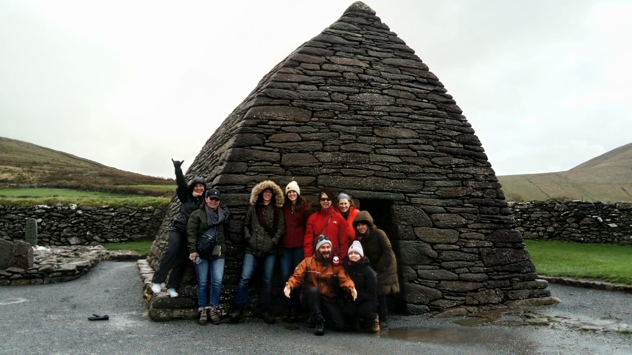 Groupe de personnes posant devant une structure en pierre.