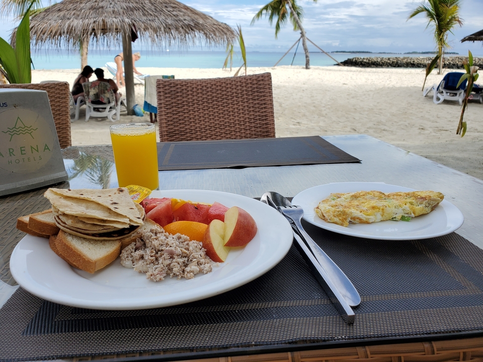 Petit-déjeuner et jus servis sur une table en bord de mer.
