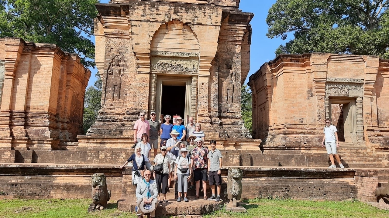Groupe de touristes posant devant des temples anciens.