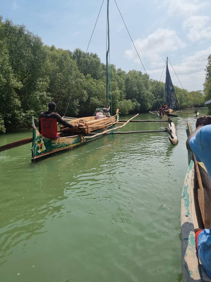 Des gens sur un bateau traditionnel dans une rivière.