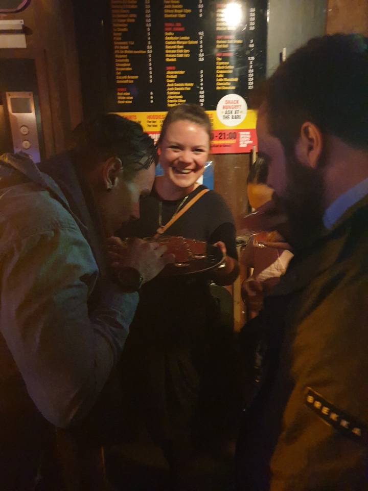 Des gens qui savourent des boissons dans un cadre intérieur tamisé.