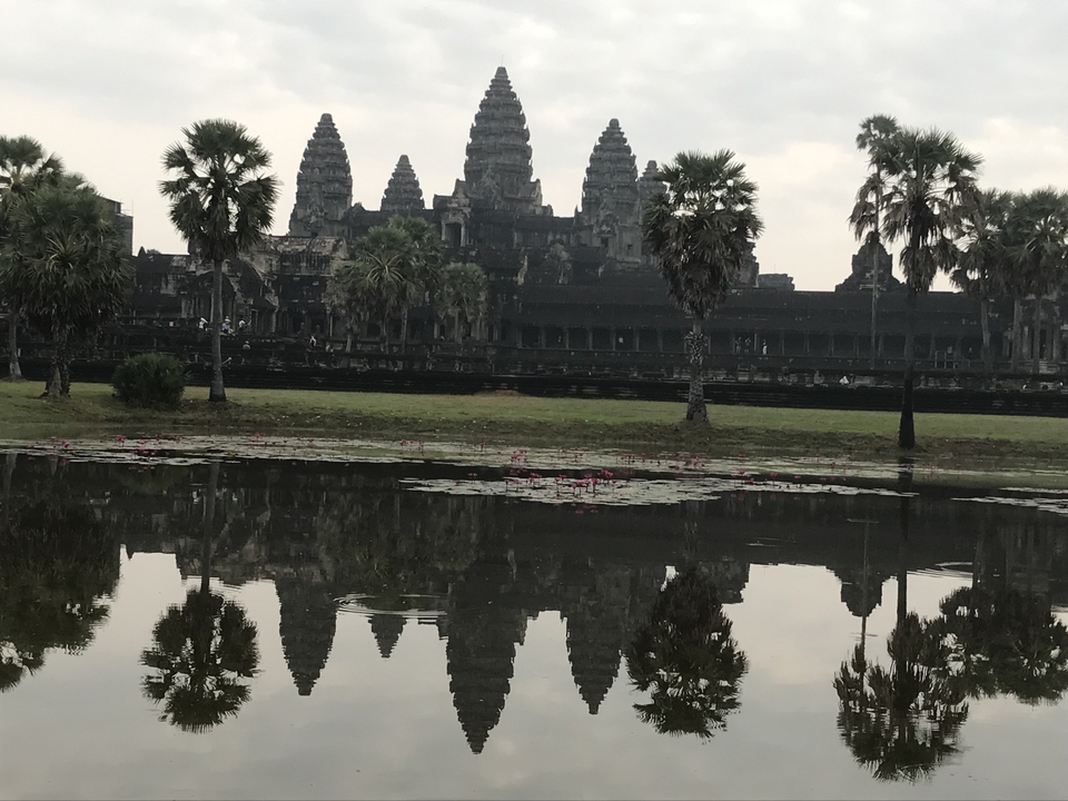 Vue emblématique du temple d'Angkor Vat avec son reflet dans un bassin.