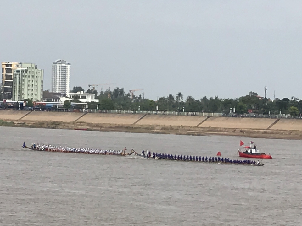 Course de bateaux se déroulant sur une large rivière regardée par des spectateurs.