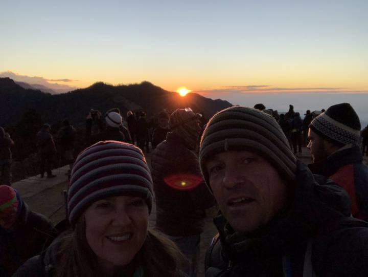 Caminata al amanecer con personas en ropa abrigada en las montañas.