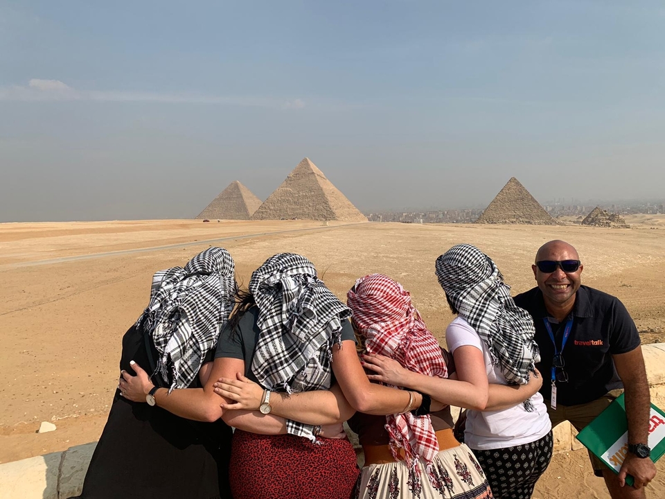 Groupe posant avec les pyramides en arrière-plan.
