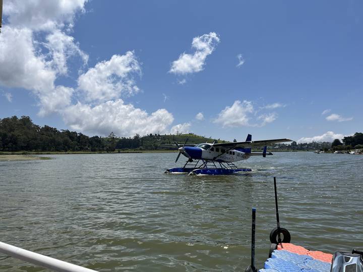 Hydravion flottant sur une étendue d'eau avec un ciel nuageux.