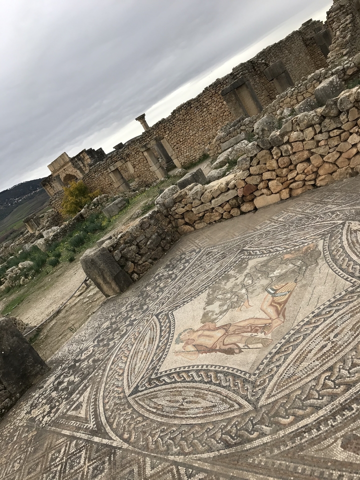 Ruines antiques avec des motifs de mosaïque au sol.