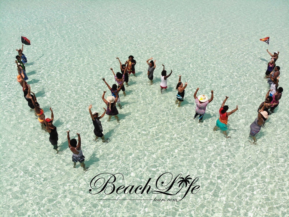 Groupe de personnes debout dans l'eau peu profonde formant des formes.