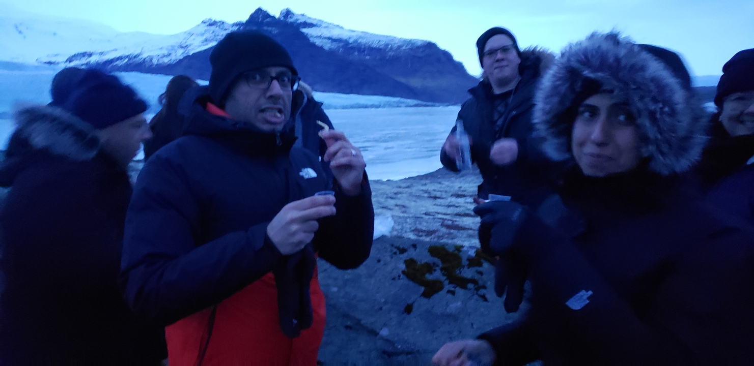 Group of people wearing warm clothing in a cold landscape.