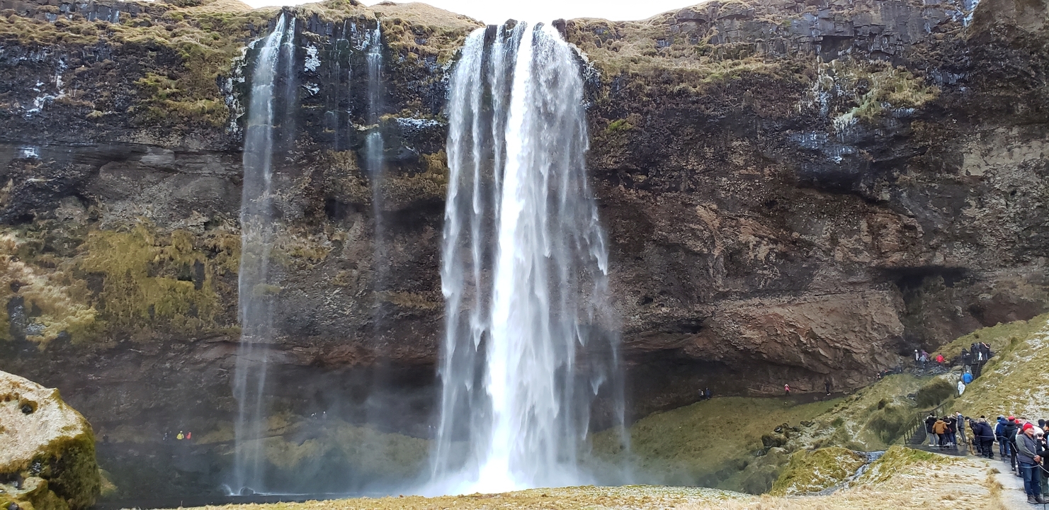 Waterfall cascading down a moss-covered cliff.