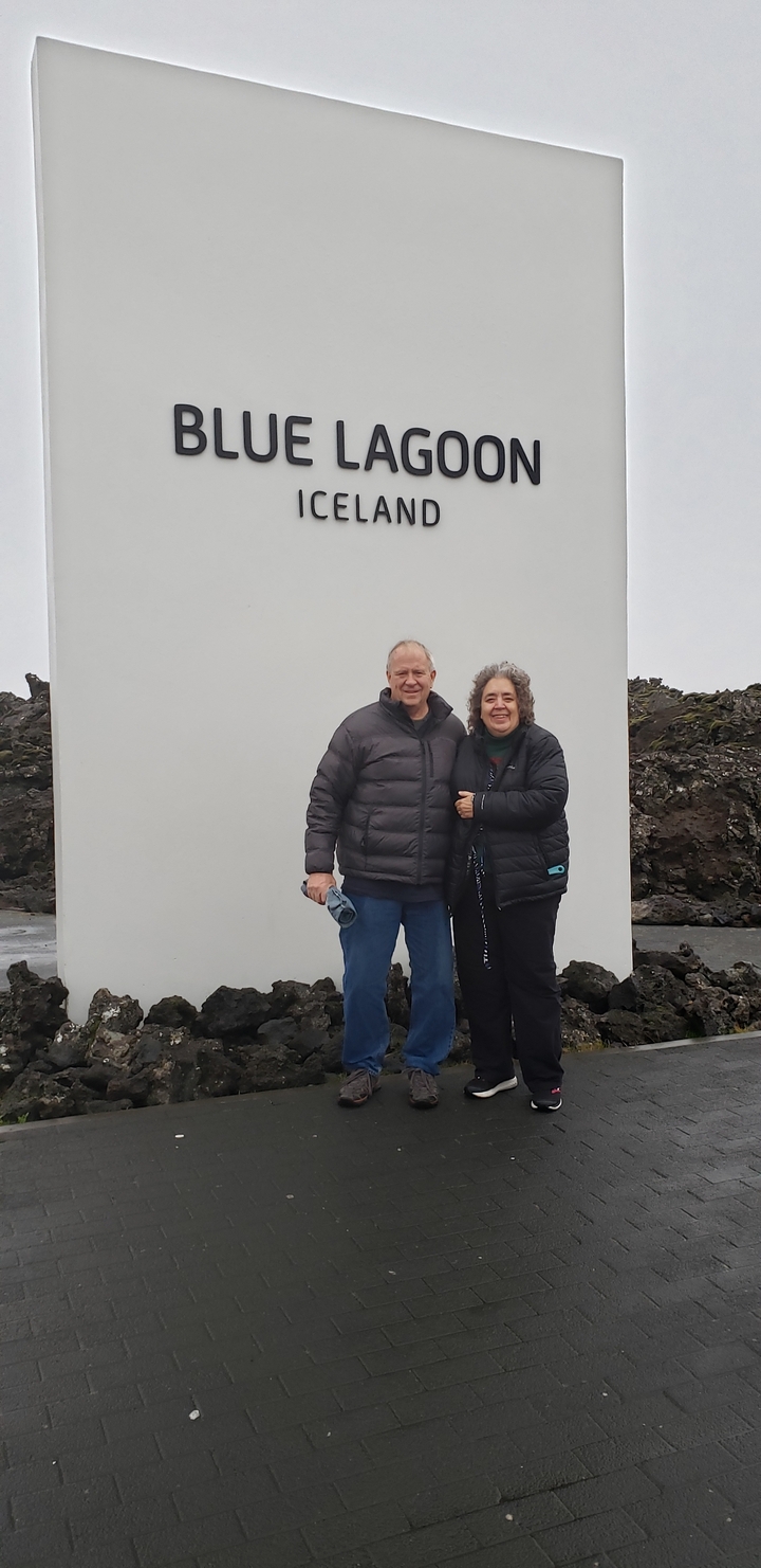 Two people posing in a rugged outdoor environment.