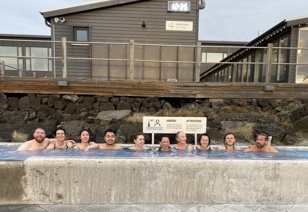 Group of people relaxing in an outdoor hot pool.
