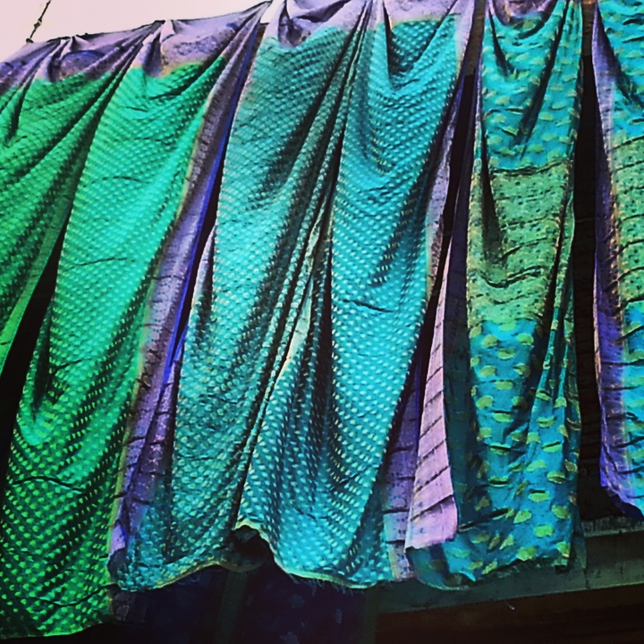 Colorful draped fabrics with intricate patterns.