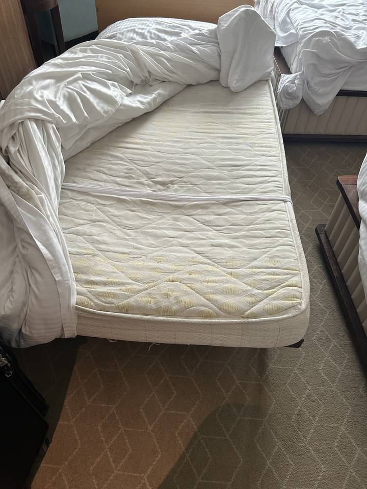 Blick von unten auf eine Matratze mit sichtbaren Flecken.