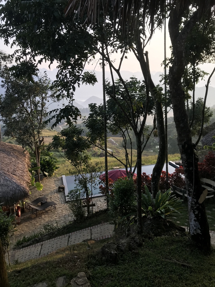 Vue luxuriante du jardin depuis une terrasse, avec vue sur les montagnes.