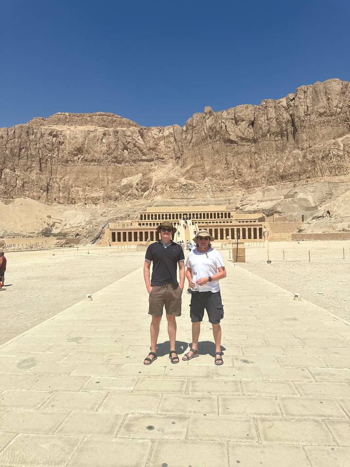 Deux personnes debout devant des ruines antiques.