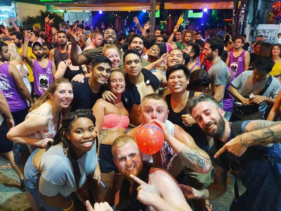 Large group of people smiling and partying in a festive setting.