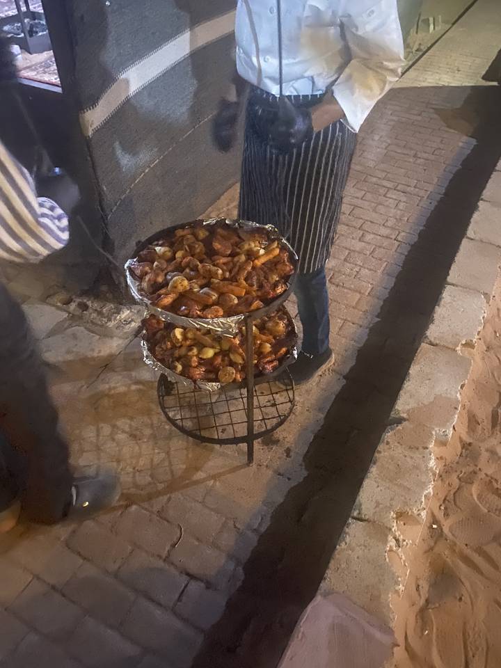 Nourriture préparée sur un grill avec une personne à proximité.
