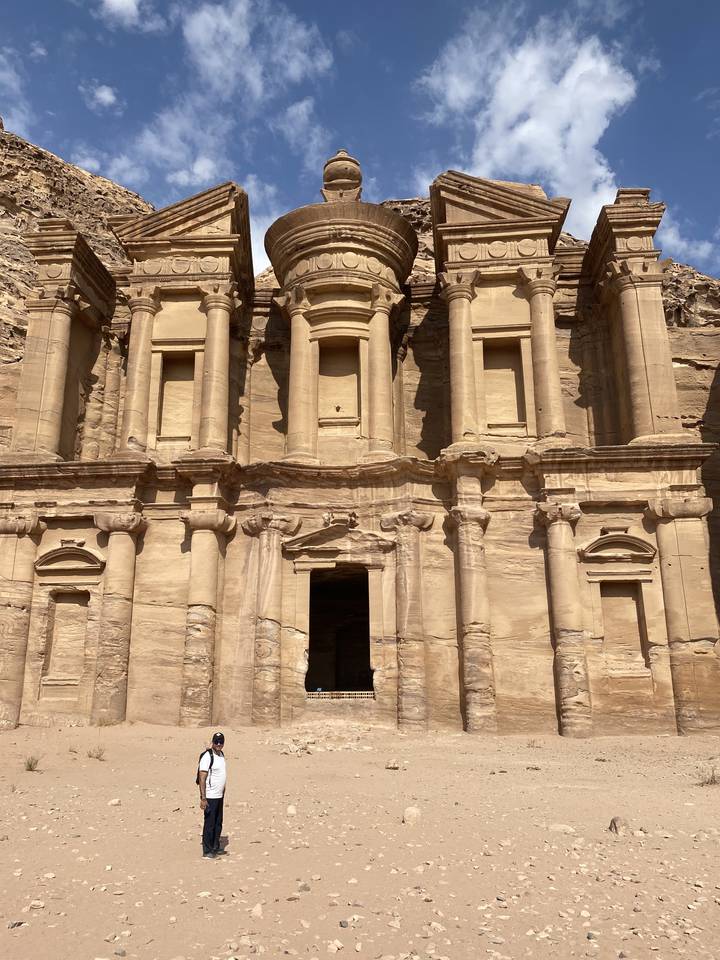 Bâtiment historique en pierre avec une personne debout au premier plan.