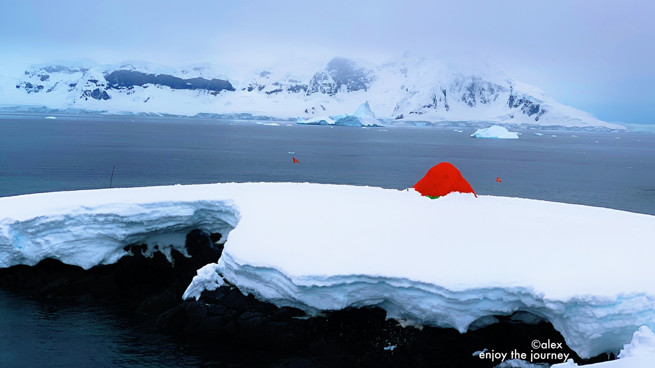 Paysage enneigé avec des icebergs et des montagnes en arrière-plan.