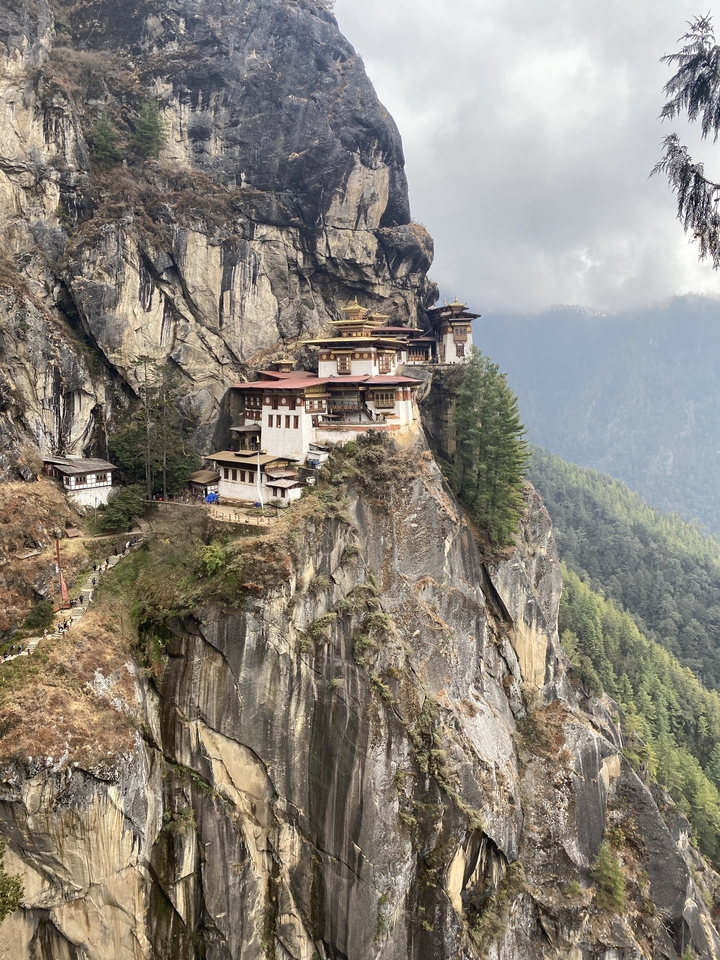 Vue panoramique d'un monastère construit sur une falaise rocheuse.