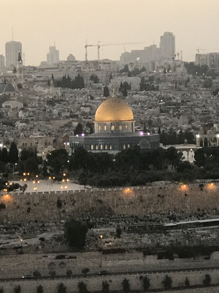 Dôme du Rocher et paysage urbain environnant au crépuscule.