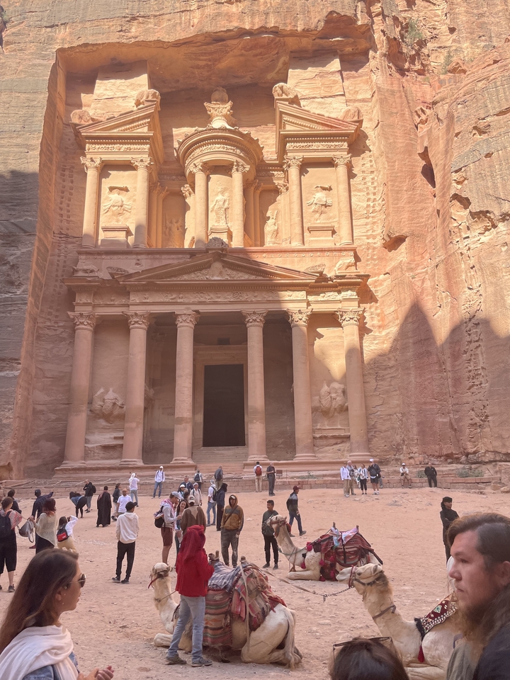La célèbre façade de Pétra en plein jour avec de minuscules personnes devant.
