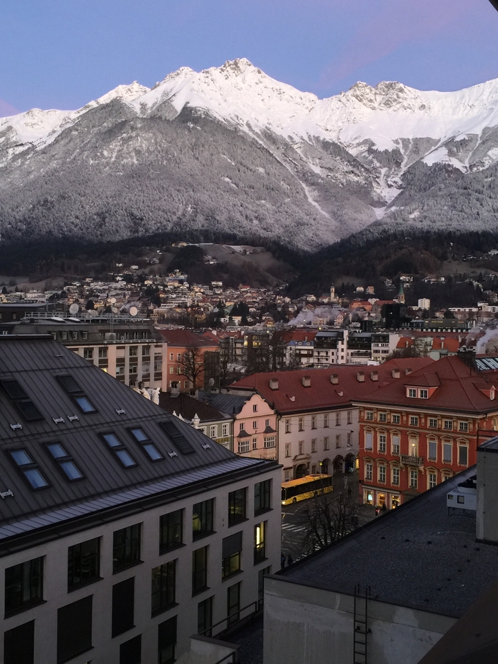 Vue aérienne d'une ville couverte de neige avec des montagnes en arrière-plan.