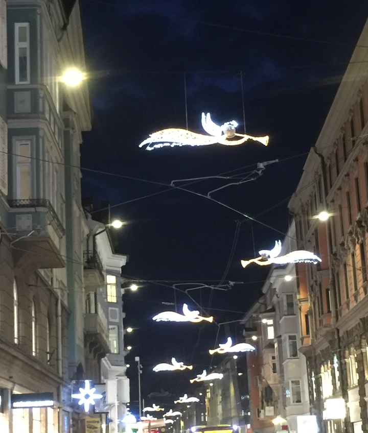 Décorations de rue avec des figures angéliques et des éclairages nocturnes.